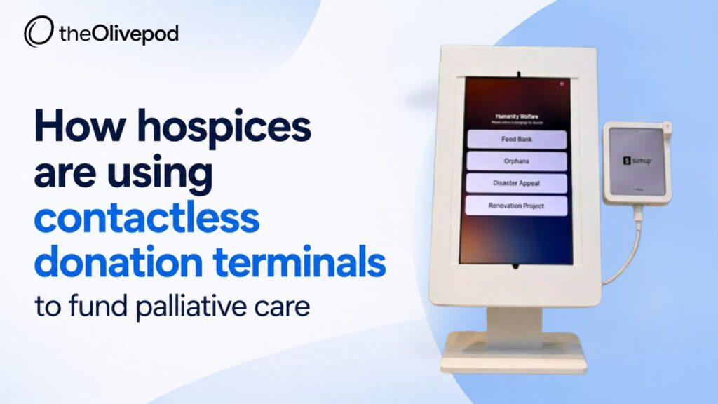 A visitor making a tap-to-donate contribution on a contactless donation terminal from TheOlivePod in a hospice reception area.
